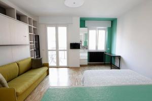 - un salon avec un canapé jaune et un lit dans l'établissement 55Birds - San Siro ed il centro a portata di mano, à Milan