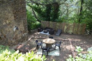 um pátio com uma mesa, cadeiras e um sofá em Gîte Almanda - Calme & Nature - Mas Lou Castanea em Collobrières