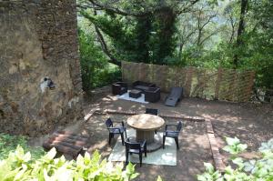 een patio met een tafel en stoelen en een bank bij Gîte Almanda - Calme & Nature - Mas Lou Castanea in Collobrières