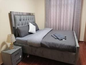 a bedroom with a large bed with a hat on it at Serene apartment in the suburbs in Nairobi