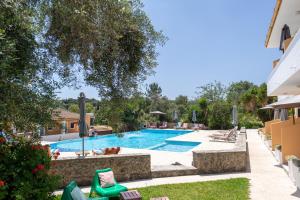 a swimming pool in the backyard of a house at Little Corfu in Dassia