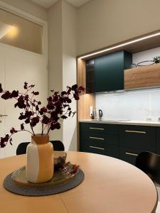uma cozinha com uma mesa com um vaso sobre ela em Visit Debrecen 3 Apartman em Debrecen