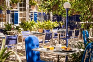 an outdoor patio with tables and chairs and plants at Hotel Medium Renaixença in Sitges