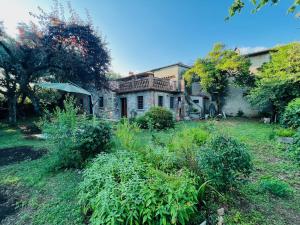 una casa antigua con un jardín delante de ella en La Casina di Susy, en Seravezza