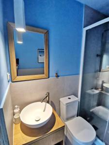 W łazience znajduje się umywalka, toaleta i lustro. w obiekcie Sea and Sand w Elafónisos