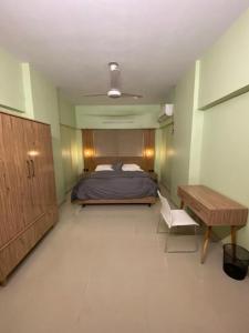 1 dormitorio con cama, escritorio y mesa en 3 Bed DD Luxury Apt SMCHS, en Karachi