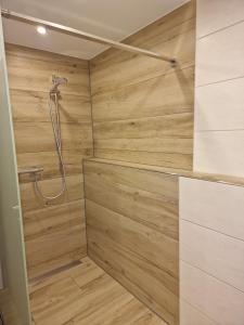 a bathroom with a shower with a wooden wall at Ferienwohnung Leibl in Oberviechtach
