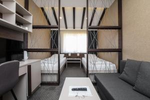 a small room with a couch and two beds at Atrijum Apartments and Rooms - Đerdap Boat Tours in Kladovo