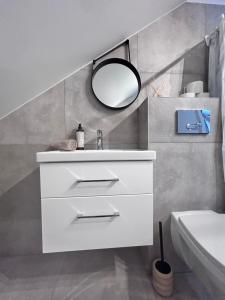a white bathroom with a sink and a mirror at Cozy and new apartment , 5km Palanga to the center. in Vydmantai