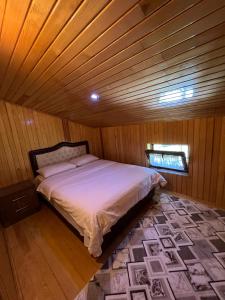 a bedroom with a bed in a wooden room at Zeren Pansiyon in Uzungöl