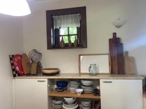 a kitchen with a shelf with dishes and a mirror at Komfortowy dom w lesie in Miedzichowo +36 photos