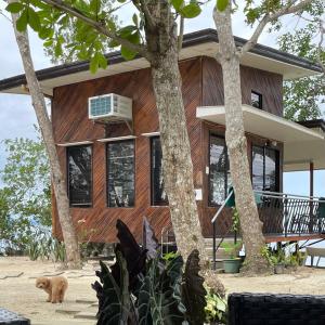 une maison avec un chien debout devant elle dans l'établissement Tabique by the Sea, à Asturias