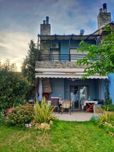 a blue house with a patio and a table at Villa Alexander in Xanthi