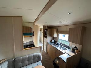 eine kleine Küche mit einer Spüle und einer Theke in der Unterkunft 27 Rickardos Holiday Lets 3-Bed Caravan near Mablethorpe in Saltfleet