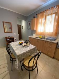 a kitchen with a table and chairs and a kitchen with a sink at nikol_house in Alepou