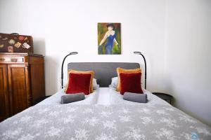 een slaapkamer met een bed met rode kussens en een schilderij bij Travel by 3City Rentals in Sopot