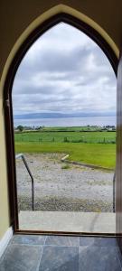 une fenêtre cintrée avec vue sur un champ dans l'établissement Tullyally's View, à Red Castle