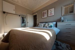 a bedroom with a large bed and a dresser at Cosy 1 Bed Apartment In Lincoln in Lincoln