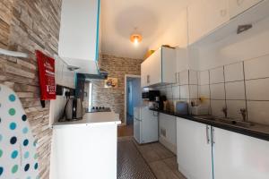 a kitchen with white cabinets and a brick wall at Cosy 1 Bed Apartment In Lincoln in Lincoln