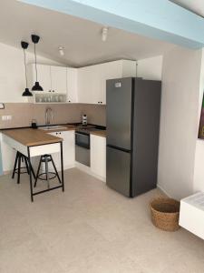 a kitchen with a black refrigerator and a table at Riva House Tribunj in Tribunj
