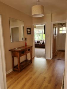 a living room with a wooden table and a mirror at Grace Lodge in Southbourne