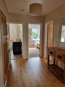 uma sala de estar com piso em madeira e uma cozinha em Grace Lodge em Southbourne