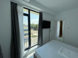 a bedroom with a bed and a large window at Oxygen Residence Neptun in Neptun