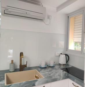 a kitchen counter with a sink and a window at Emilie Guest House in Haifa