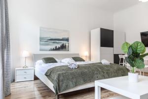 a white bedroom with a large bed and a table at Affordable 2BR Apt- Connected to the whole city in Vienna