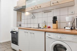 eine Küche mit einer Waschmaschine und einem Waschbecken in der Unterkunft Affordable 2BR Apt- Connected to the whole city in Wien