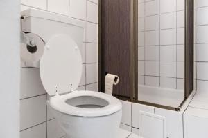 - białą toaletę w łazience z lustrem w obiekcie Affordable 2BR Apt- Connected to the whole city w Wiedniu
