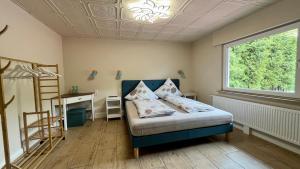 Quiddelbach的住宿－Franky House am Nürburgring，一间卧室配有一张床、一张书桌和一个窗户。
