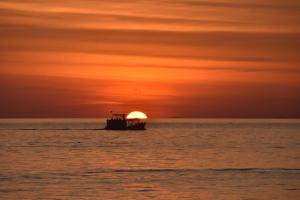 una barca nell'oceano al tramonto di Pinnacle Koh Tao Resort a Ko Tao