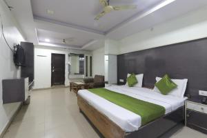 a bedroom with a large bed with a green blanket at Hotel Dayal in Lucknow