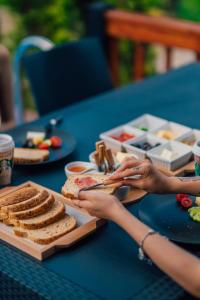 einen Tisch mit einem Teller Brot und eine Person mit einem Sandwich in der Unterkunft Palm Bungalov Hotel in Kartepe