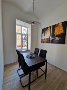 a dining room with a black table and chairs at Apartment CITY Ostrava in Moravská Ostrava