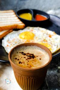 a fried egg on a plate with a cup of coffee at Mitra Hostel Mcleodganj in McLeod Ganj