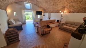 a living room with a couch and a table and chairs at Villa Podere I Cavalieri in SantʼAnna