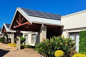 ein Haus mit Sonnenkollektoren auf dem Dach in der Unterkunft @ Marula in Mokopane