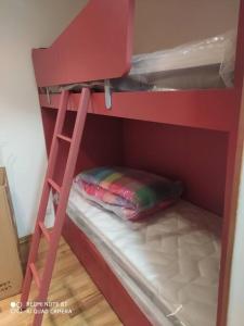 a red bunk bed with a ladder and a pillow at Giappetto House in Limone Piemonte