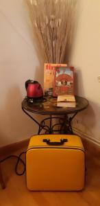 a table with around table with a table with a yellow suitcase at Bell'Accueil Chambres d'Hôtes Cluny in Cluny