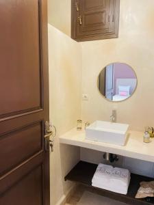 W łazience znajduje się umywalka i lustro. w obiekcie Riad Deha & Spa w Marakeszu