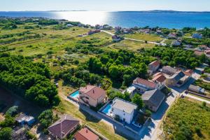 an aerial view of a house with the ocean in the background at Villa Nelly in Privlaka
