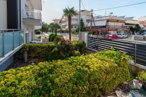 a balcony of a building with bushes and flowers at BLACK & WHITE CITY VILLA in Alexandroupoli