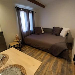 une chambre avec un lit, une table et une fenêtre dans l'établissement Studio LA MOUTONNE tt équipé 20 m2 10mn plages- hyeres - TRES CALME-, à La Crau