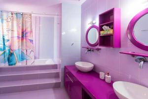 La salle de bains rose est pourvue d'un lavabo et d'un miroir. dans l'établissement BLACK & WHITE CITY VILLA, à Alexandroúpolis