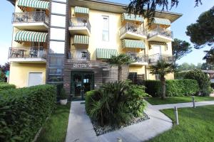 a yellow building with balconies and plants in front of it at Hotel Campanello in Castelnuovo del Garda