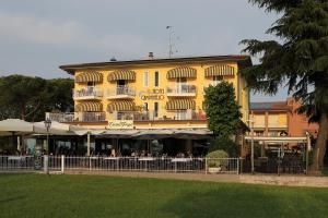 a yellow building with a restaurant in front of it at Hotel Campanello in Castelnuovo del Garda