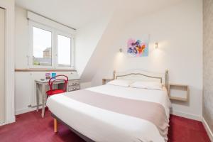 una camera con letto, scrivania e finestra di Hotel De L'Agriculture - 2 étoiles a Saint-Hilaire-du-Harcouët