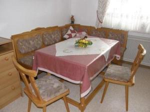 einen Tisch und zwei Stühle mit einem Tisch und einem Sofa in der Unterkunft Haus Kröll in Mittersill